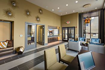 an open lobby with chairs and tables at Reveal Hackensack apartments